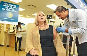 TORONTO, ON- OCTOBER 24 - Getting her flu shot from pharmacist Hitesh Pandya looking brave as Health Minister Deb Matthews kicked off flu vaccination season today at Shoppers Drug Mart on Yonge St in Toronto.With the flu season on our door step and the flu vaccines now available and can be given at around 2000 pharmacies across Ontario for the second year as well as in your workplace or doctors office. between 3.4 million and 8.6 million Canadians get the flu each year and it can result in serious health consequences for many. at in Toronto, October 24, 2013. Colin McConnell/Toronto Star