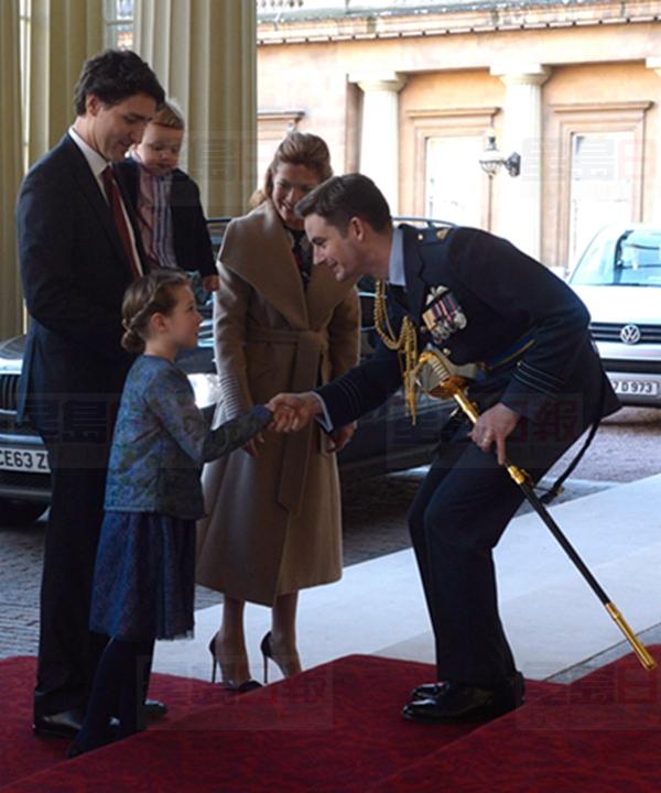 Queen's equerry Wing Cmdr. Sam Fletcher, right, shakes hands with Ella-Grace Trudeau as he greets Canadian Prime Minister Justin Trudeau, left, his wife Sophie Gregoire-Trudeau, and son Hadrien in London on Wednesday, Nov. 25, 2015. THE CANADIAN PRESS/Adrian Wyld