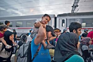 A Syrian refugee child reacts while held by his father as they wait to be allowed by Croatian police to board a train at the station in Tovarnik, Croatia, Saturday, Sept. 19, 2015. Police said Saturday more people are coming in from Serbia, mostly near the eastern border town of Tovarnik, where there are already 2,500 people waiting for transport. (AP Photo/Muhammed Muheisen)