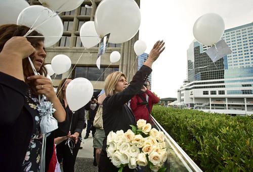 Tima Kurdi, centre, aunt of late brothers Alan and Ghalib Kurdi, releases a balloon in memory of the boys after a memorial service in Vancouver, B.C., on Saturday September 5, 2015. The body of 3-year-old Syrian Alan Kurdi was found on a Turkish beach after the small rubber boat he, his 5-year old brother Ghalib and their mother Rehanna were in capsized during a desperate voyage from Turkey to Greece. THE CANADIAN PRESS/Darryl Dyck