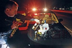 OPP PATROL THE 400 SERIES---07/01/07---An OPP officer checks the stash of alcohol from a car filled with five young me driving back to Quebec from Wasaga Beach and open alcohol pulled over by OPP officer Duane McKnight. McKnight patrols the 400 series highways north of Toronto in an unmarked car looking for dangerous drivers, July 1, 2007. Officer Duane McKnight is also a licenced mechanic who does forensics on totaled cars. (Steve Russell/Toronto Star) sjr