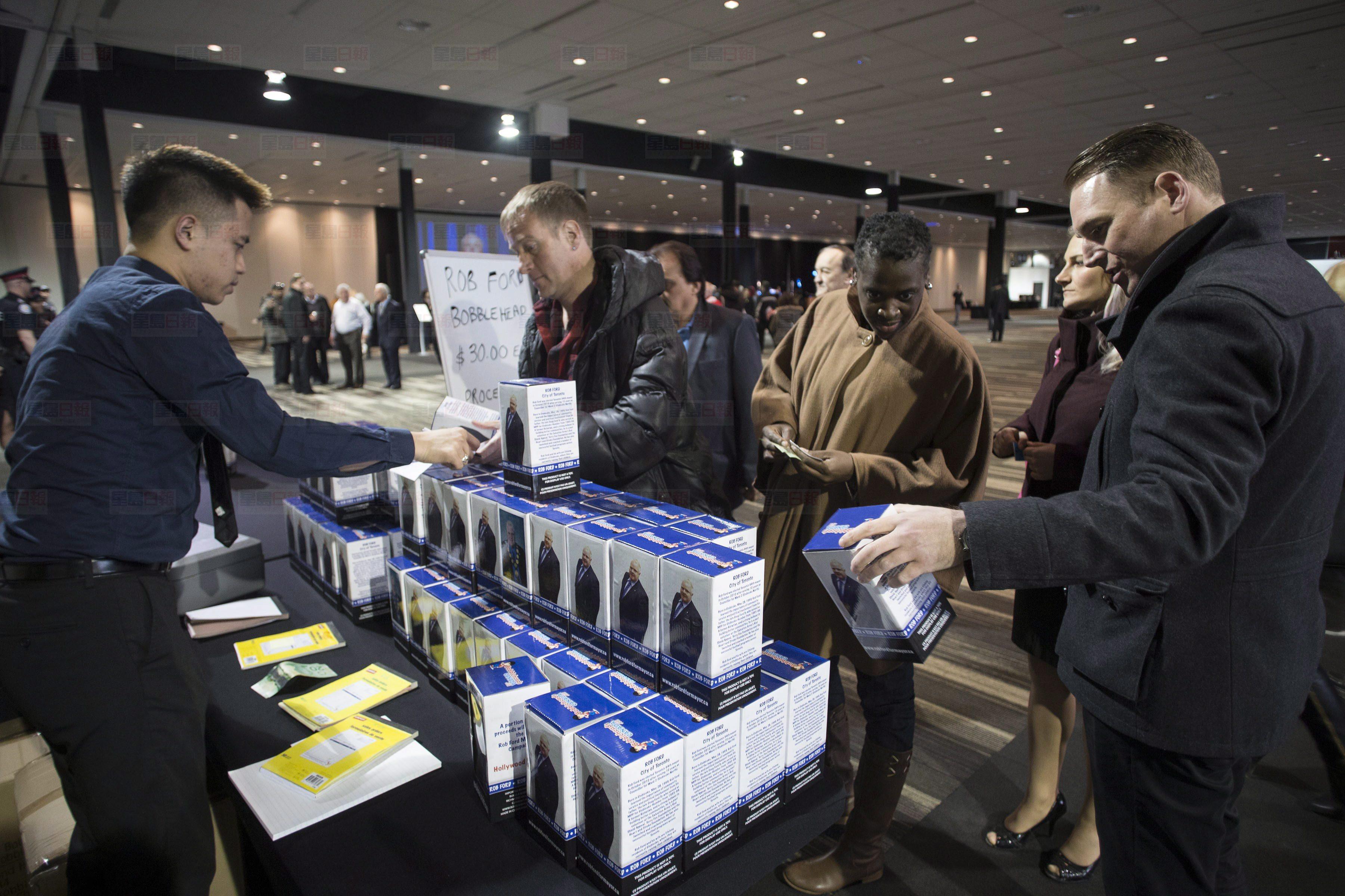 Ford Nation supporters buy bobblehead figures of Rob Ford, as money is raised for cancer research at an event to mark a celebration of Rob Ford's life at the Toronto Congress Centre, on Wednesday, March 30, 2016. Ford died of cancer last week at the age of 46. THE CANADIAN PRESS/Chris Young