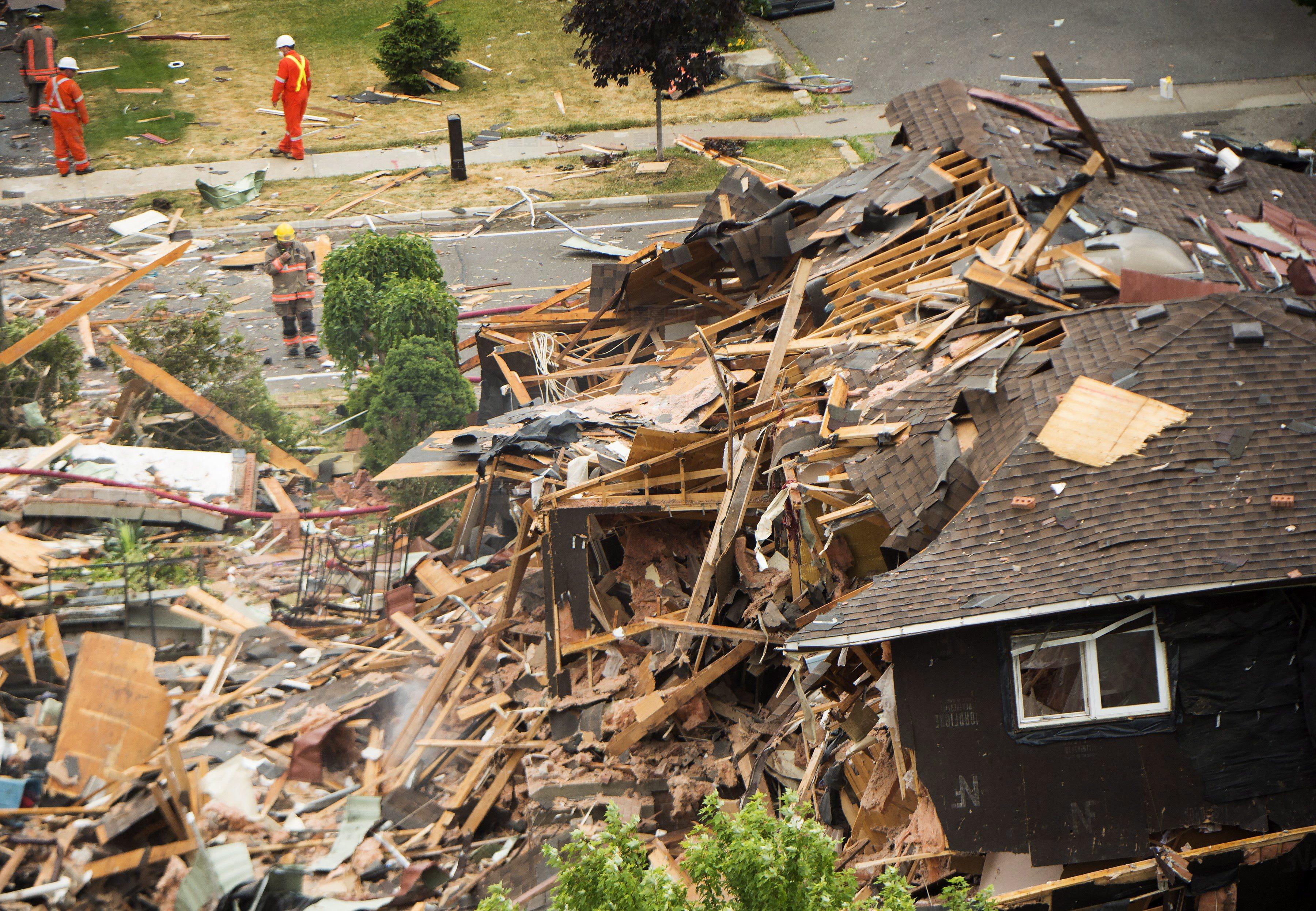 Firefighters and emergency personal work at the scene after a home explosion happened in Mississauga, Ont., on Tuesday, June 28, 2016. THE CANADIAN PRESS/Nathan Denette