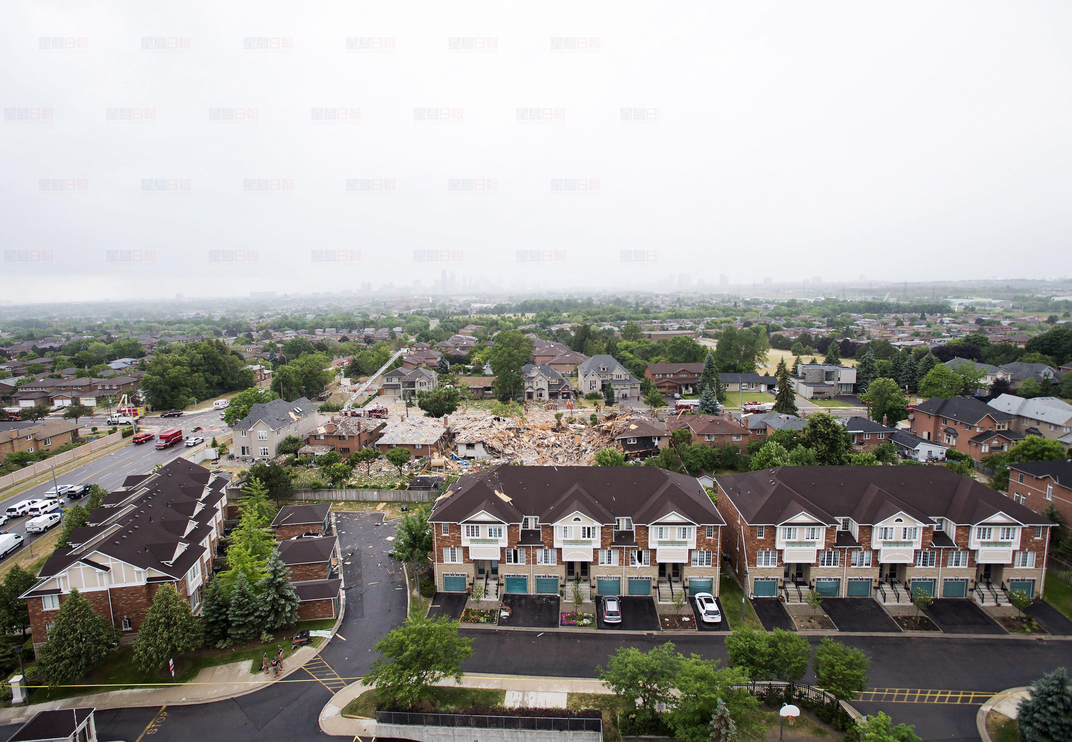 Firefighters and emergency personal work at the scene after a home explosion happened in Mississauga, Ont., on Tuesday, June 28, 2016. THE CANADIAN PRESS/Nathan Denette