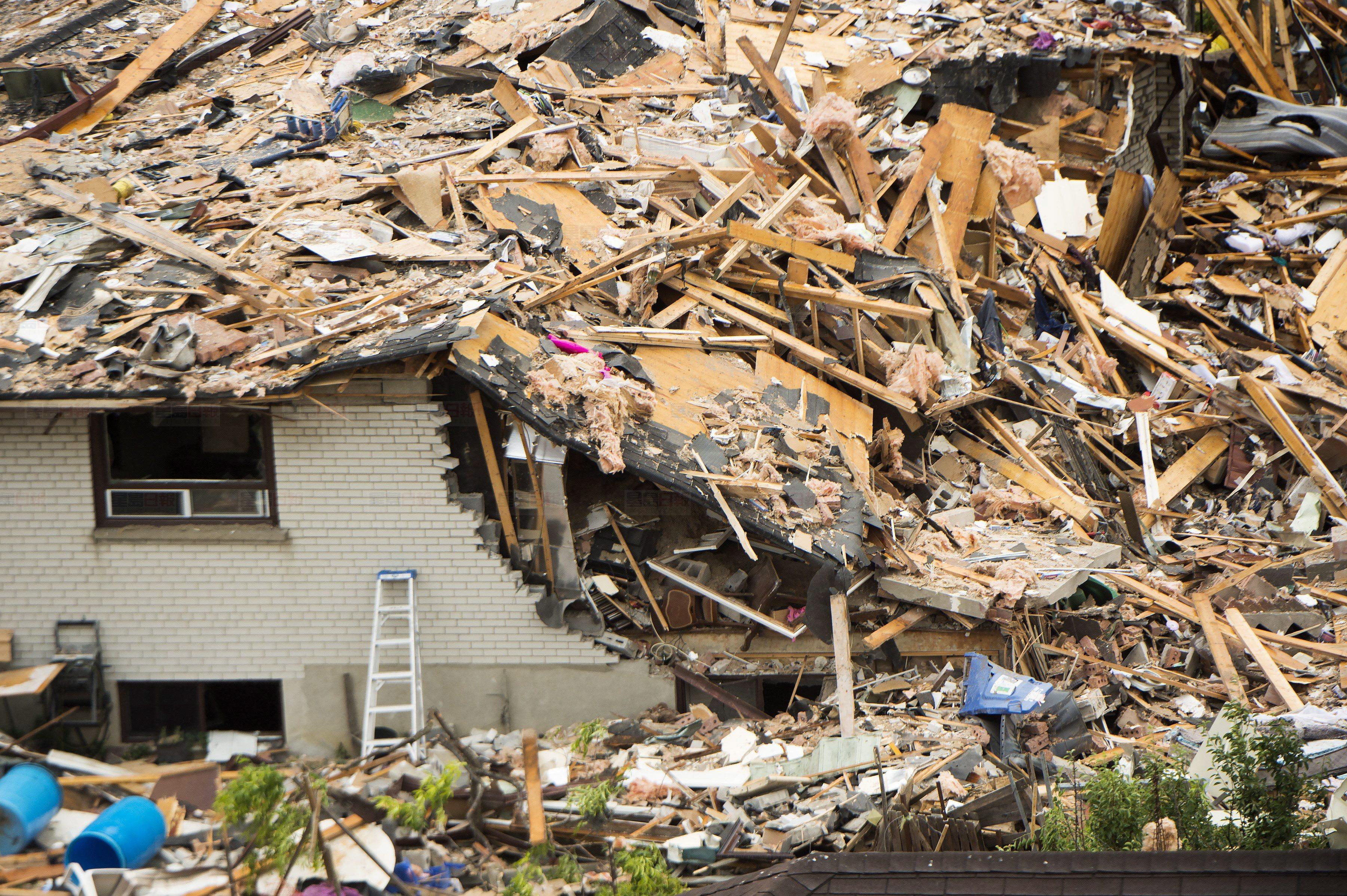 Firefighters and emergency personal work at the scene after a home explosion happened in Mississauga, Ont., on Tuesday, June 28, 2016. THE CANADIAN PRESS/Nathan Denette