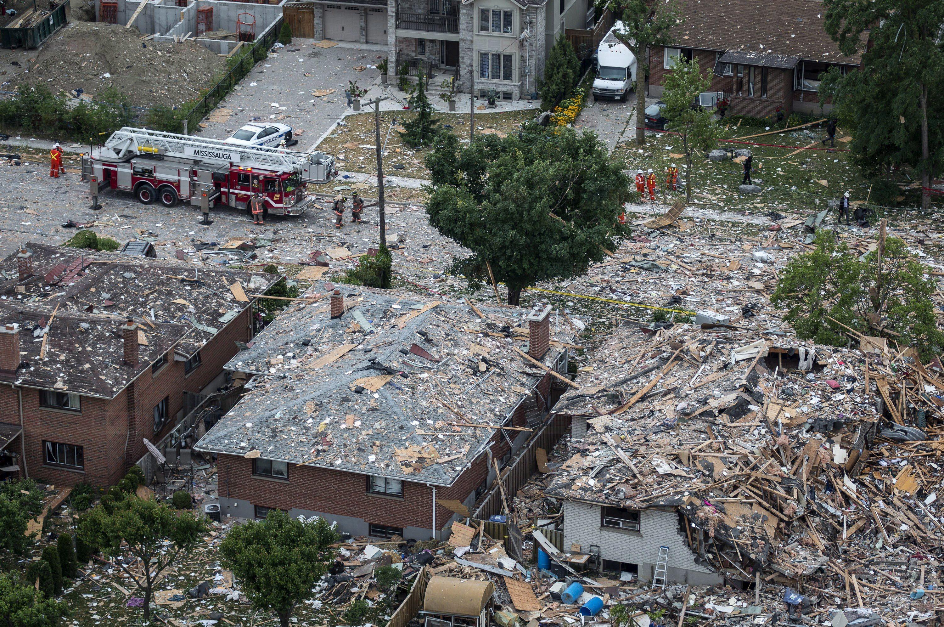 Firefighters examine debris after a house explosion in Mississauga, Ont., Tuesday, June 28, 2016. THE CANADIAN PRESS/Eduardo Lima.