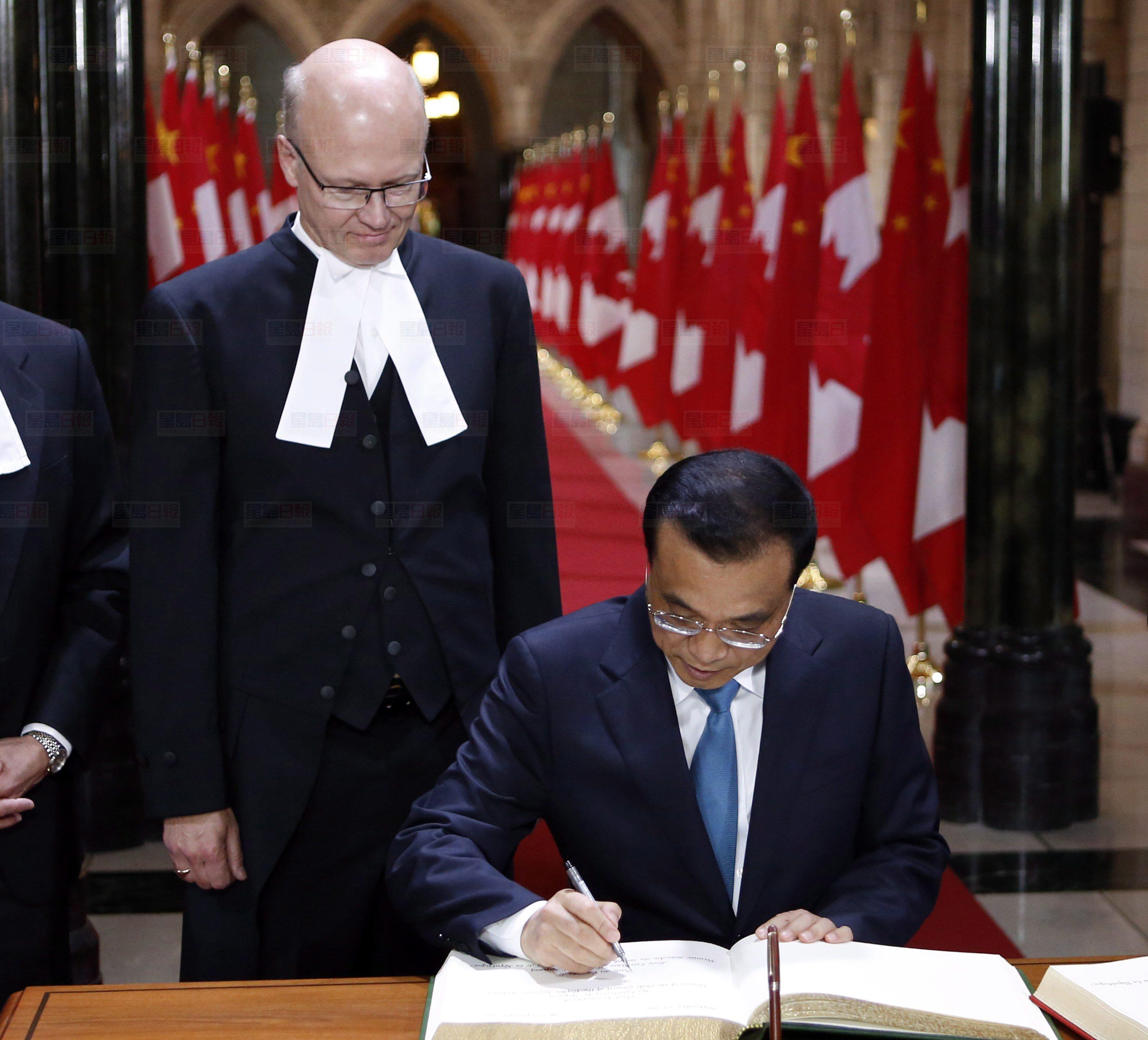 Premier of the State Council of the People's Republic of China Li Keqiang signs a guest book as House of Commons speaker Geoff Regan, left, looks on in Ottawa Thursday, September 22, 2016. THE CANADIAN PRESS/Fred Chartrand