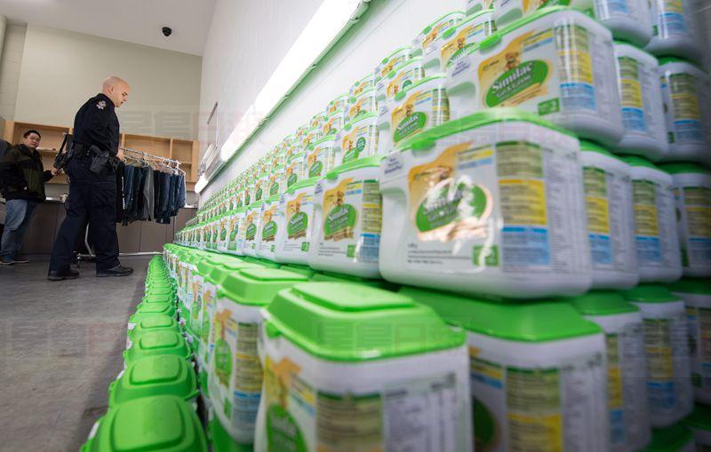 Vancouver Police Cnst. Jason Doucette looks at some of the $50,000 worth of stolen baby formula that was recovered by police, during a news conference, in Vancouver on Thursday, November 17, 2016. Police received information in October about a man who was purchasing large quantities of stolen baby formula and allegedly shipping it to China for a large profit. THE CANADIAN PRESS/Darryl Dyck