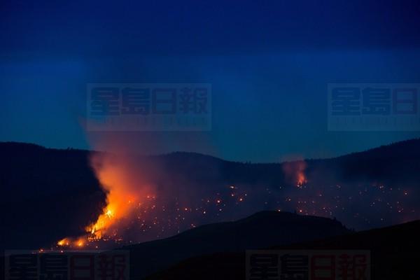 A wildfire burns on a mountain near Ashcroft, B.C., late Friday July 7, 2017. More than 3,000 residents have been evacuated from their homes in central British Columbia. A provincial state of emergency was declared after 56 new wildfires started Friday. THE CANADIAN PRESS/Darryl Dyck
