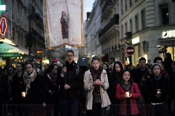 People walk toward the Notre Dame Cathedral to attend a vigil, in Paris, Tuesday April 16, 2019. Firefighters declared success Tuesday in a more than 12-hour battle to extinguish an inferno engulfing Paris' iconic Notre Dame cathedral that claimed its spire and roof, but spared its bell towers and the purported Crown of Christ. (AP Photo/Kamil Zihnioglu)