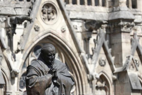 The statue of Pope John Paul II is pictured outside of Notre Dame cathedral Wednesday, April 17, 2019 in Paris. Notre Dame Cathedral would have been completely burned to the ground in a "chain reaction collapse" had firefighters not moved rapidly in deploying their equipment to battle the blaze racing through the landmark monument, a Paris official said Wednesday. (AP Photo/Thibault Camus)