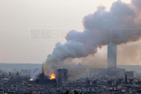Notre Dame cathedral burning in Paris, Monday, April 15, 2019. Massive plumes of yellow brown smoke is filling the air above Notre Dame Cathedral and ash is falling on tourists and others around the island that marks the center of Paris. (AP Photo/Rafael Yaghobzadeh)