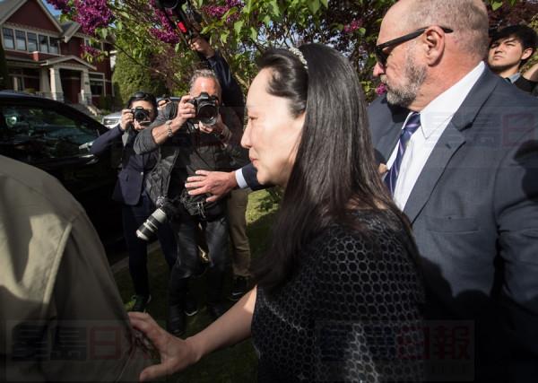 Huawei chief financial officer Meng Wanzhou, centre, who is out on bail and remains under partial house arrest after she was detained Dec. 1 at the behest of American authorities, is accompanied by a private security detail as she leaves her home to attend a court appearance in Vancouver, on Wednesday May 8, 2019. THE CANADIAN PRESS/Darryl Dyck