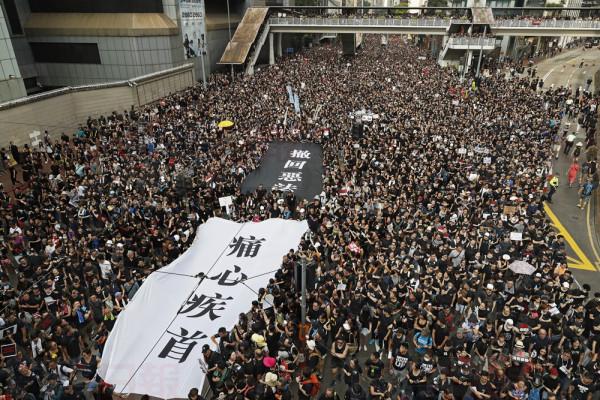 Protesters carry a huge banner reading "Our hearts are torn to pieces. Withdraw the monstrous bill" as they march on the streets against an extradition bill in Hong Kong on Sunday, June 16, 2019. Hong Kong residents Sunday continued their massive protest over an unpopular extradition bill that has highlighted the territory's apprehension about relations with mainland China, a week after the crisis brought as many as 1 million into the streets. (AP Photo/Vincent Yu)