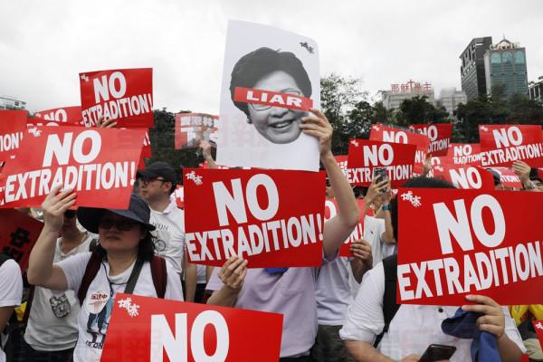 Protesters hold placards as they stage protest against the extradition law in Hong Kong, Sunday, June 9, 2019. The extradition law has aroused concerns that this legislation would undermine the city's independent judicial system as it allows Hong Kong to hand over fugitives to the jurisdictions that the city doesn't currently have an extradition agreement with, including mainland China, where a fair trial might not be guaranteed. (AP Photo/Vincent Yu)