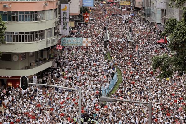 Protesters march along a downtown street against the proposed amendments to an extradition law in Hong Kong Sunday, June 9, 2019. The amendments have been widely criticized as eroding the semi-autonomous Chinese territory's judicial independence by making it easier to send criminal suspects to mainland China, where they could face vague national security charges and unfair trials. (AP Photo/Vincent Yu)