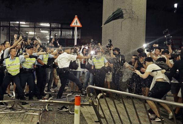 Police officers use pepper spray against protesters in a rally against the proposed amendments to the extradition law at the Legislative Council in Hong Kong during the early hours of Monday, June 10, 2019. The extradition law has aroused concerns that this legislation would undermine the city's independent judicial system as it allows Hong Kong to hand over fugitives to the jurisdictions that the city doesn't currently have an extradition agreement with, including mainland China, where a fair trial might not be guaranteed. (AP Photo/Vincent Yu)