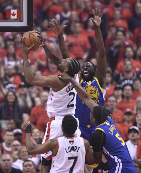 Toronto Raptors forward Kawhi Leonard (2) goes up for a basket while under pressure from Golden State Warriors forward Draymond Green (23) and Warriors centre Kevon Looney (5) during first half basketball action in Game 5 of the NBA Finals in Toronto on Monday, June 10, 2019. THE CANADIAN PRESS/Frank Gunn