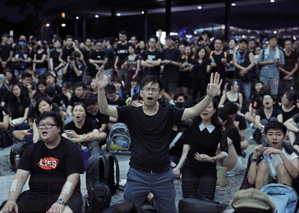 Protesters sing after a march against an extradition bill outside Legislative Council in Hong Kong on Sunday, June 16, 2019. Hong Kong residents Sunday continued their massive protest over an unpopular extradition bill that has highlighted the territory's apprehension about relations with mainland China, a week after the crisis brought as many as 1 million into the streets. (AP Photo/Vincent Yu)