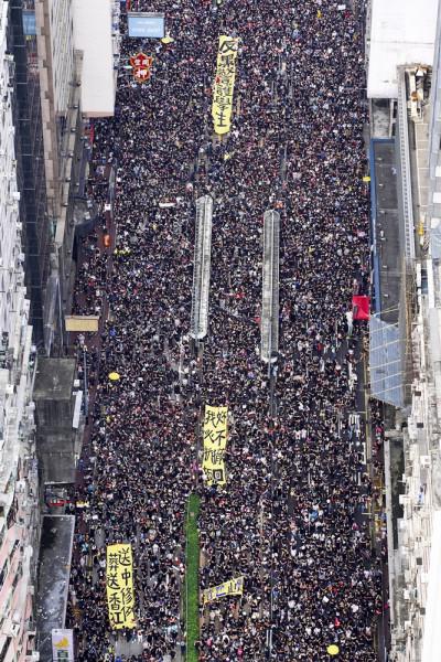Tens of thousands of protesters carrying posters and banners march through the streets as they continue to protest an extradition bill, Sunday, June 16, 2019, in Hong Kong. Hong Kong residents Sunday continued their massive protest over an unpopular extradition bill that has highlighted the territory's apprehension about relations with mainland China, a week after the crisis brought as many as 1 million into the streets. (Apple Daily via AP)