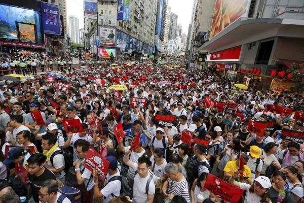 Protesters hold placards march on a street as they take part in a rally against the proposed amendments to extradition law in Hong Kong, Sunday, June 9, 2019. The amendments have been widely criticized as eroding the semi-autonomous Chinese territory's judicial independence by making it easier to send criminal suspects to mainland China, where they could face vague national security charges and unfair trials. (AP Photo/Kin Cheung)