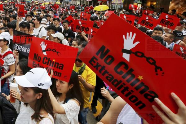 Protesters hold placards march on a street as they take part in a rally against the proposed amendments to extradition law in Hong Kong, Sunday, June 9, 2019. The amendments have been widely criticized as eroding the semi-autonomous Chinese territory's judicial independence by making it easier to send criminal suspects to mainland China, where they could face vague national security charges and unfair trials. (AP Photo/Kin Cheung)