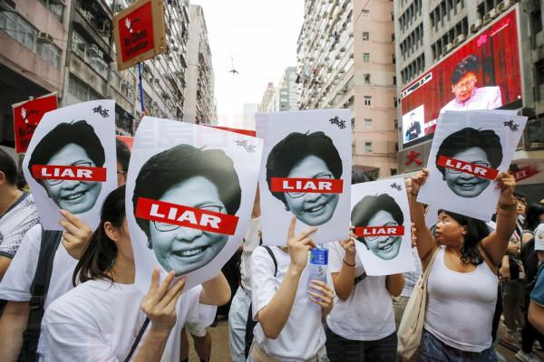 Protesters hold pictures of Hong Kong Chief Executive Carrie Lam as protesters march along a downtown street against the proposed amendments to an extradition law in Hong Kong Sunday, June 9, 2019. A sea of protesters is marching through central Hong Kong in a major demonstration against government-sponsored legislation that would allow people to be extradited to mainland China to face charges. (AP Photo/Kin Cheung)