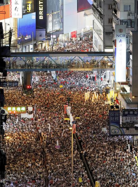 Protesters march on a downtown street during a rally against the proposed amendments to an extradition law in Hong Kong, Sunday, June 9, 2019. The extradition law has aroused concerns that this legislation would undermine the city's independent judicial system as it allows Hong Kong to hand over fugitives to the jurisdictions that the city doesn't currently have an extradition agreement with, including mainland China, where a fair trial might not be guaranteed. (AP Photo/Kin Cheung)