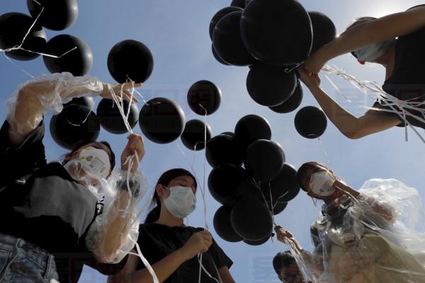 Protestors hold black balloons to symbolize mourning for Hong Kong during protests in Hong Kong on Monday, July 1, 2019. The Hong Kong government marked the 22nd anniversary of the former British colony's return to China on Monday, as police faced off with protesters outside the venue. (AP Photo/Kin Cheung)