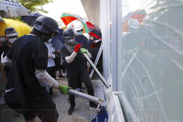Protesters try to break the glass walls of the Legislative Council in Hong Kong on Monday, July 1, 2019. Combative protesters tried to break into the Hong Kong legislature Monday as a crowd of thousands prepared to start a march in that direction on the 22nd anniversary of the former British colony's return to China. (AP Photo/Vincent Yu)