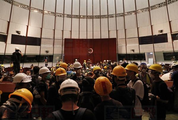 Protesters discuss at the Legislative Chamber after break in to protest against the extradition bill in Hong Kong, Monday, July 1, 2019. The extradition law has aroused concerns that this legislation would undermine the city's independent judicial system as it allows Hong Kong to hand over fugitives to the jurisdictions that the city doesn't currently have an extradition agreement with, including mainland China, where a fair trial might not be guaranteed. (AP Photo/Vincent Yu)