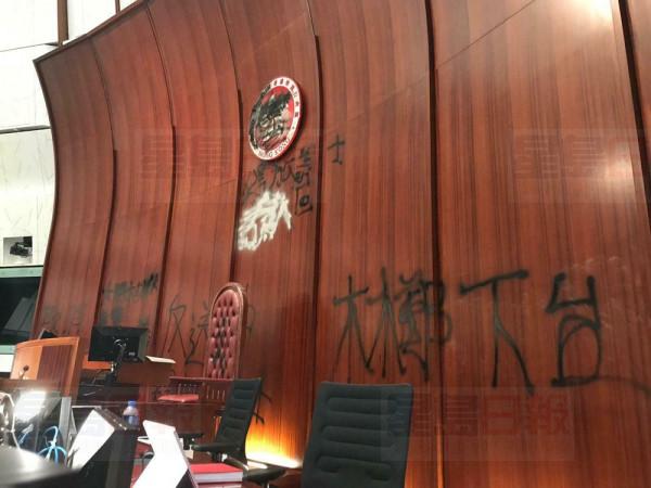 Damage to the Legislative Council following a break-in by protesters is seen during a media tour, Wednesday, July 3, 2019, in Hong Kong. Characters read "Step down Carrie Lam." (AP Photo/Johnson Lai)