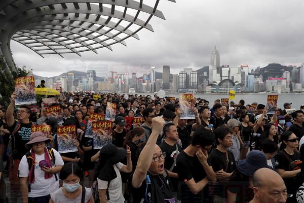 Protesters take part in a march in Hong Kong on Sunday, July 7, 2019. Protesters in Hong Kong are taking their message to visitors from mainland China on Sunday in a march to a high-speed rail station that connects to Guangdong city and other mainland destinations. (AP Photo/Kin Cheung)