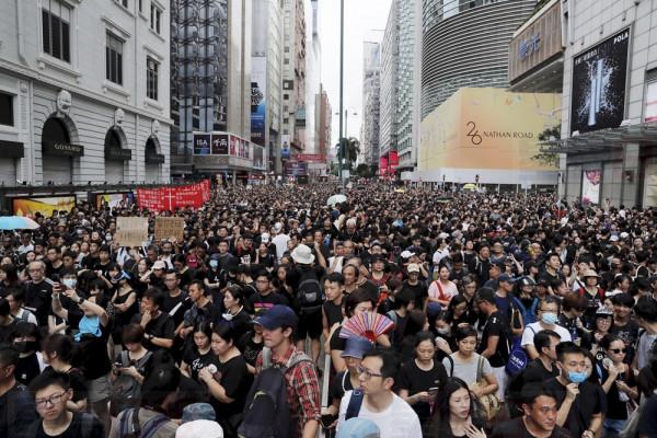 Protesters take part in a march in Hong Kong on Sunday, July 7, 2019. Protesters in Hong Kong are taking their message to visitors from mainland China on Sunday in a march to a high-speed rail station that connects to Guangdong city and other mainland destinations. (AP Photo/Kin Cheung)