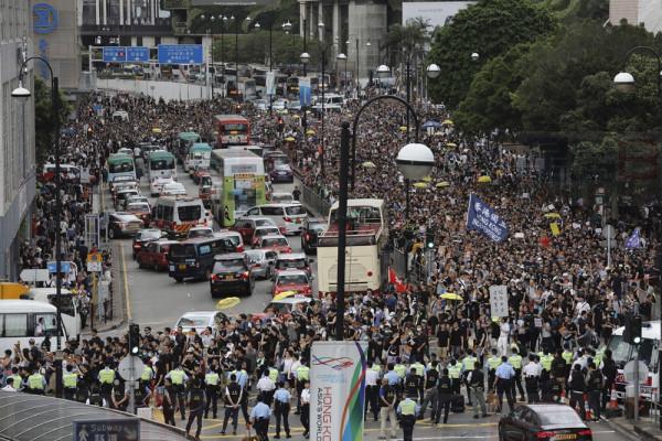 Police block the road ahead of a march by protesters in Hong Kong on Sunday, July 7, 2019. Protesters in Hong Kong are taking their message to visitors from mainland China on Sunday in a march to a high-speed rail station that connects to Guangdong city and other mainland destinations. (AP Photo/Vincent Yu)