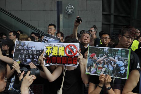 Journalists hold placards with the words "Not retreat, defend press freedom" during a silent march outside the police headquarters in Hong Kong, Sunday, July 14, 2019, demanding police to stop assaulting journalists and obstructing reporting. (AP Photo/Kin Cheung)