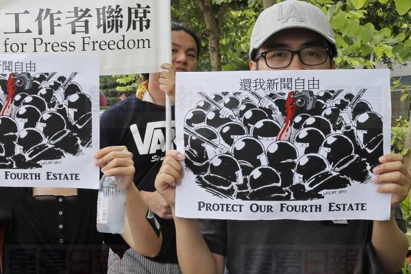 Journalists hold placards during a silent march to police and government headquarters in Hong Kong, Sunday, July 14, 2019, demanding police to stop assaulting journalists and obstructing reporting. (AP Photo/Kin Cheung)
