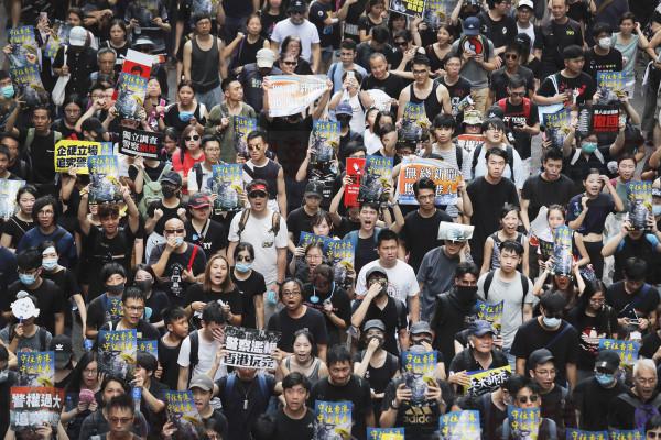 Protesters march through the streets in Sha Tin District in Hong Kong, Sunday, July 14, 2019. Opponents of a proposed Hong Kong extradition law have begun a protest march, adding to an outpouring of complaints the territory's pro-Beijing government is eroding its freedoms and autonomy. (AP Photo/Kin Cheung)