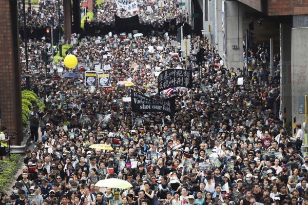 Protesters march through the Sha Tin District in Hong Kong, Sunday, July 14, 2019. Opponents of a proposed Hong Kong extradition law have begun a protest march, adding to an outpouring of complaints the territory's pro-Beijing government is eroding its freedoms and autonomy. (AP Photo/Kin Cheung)