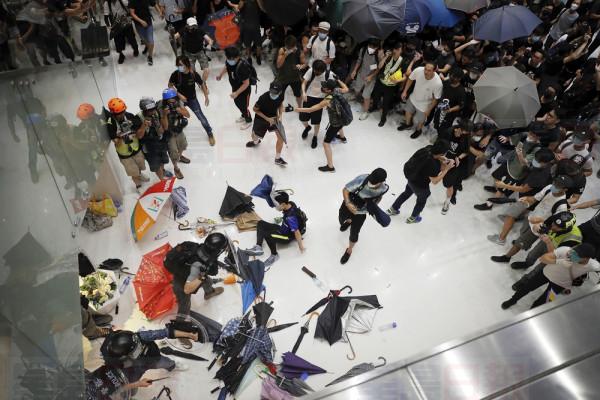 Policemen scuffle with protesters inside a shopping mall in Sha Tin District in Hong Kong, Sunday, July 14, 2019. Police in Hong Kong have fought with protesters as they broke up a demonstration by thousands of people demanding the resignation of the Chinese territory's chief executive and an investigation into complains of police violence. (AP Photo/Kin Cheung)