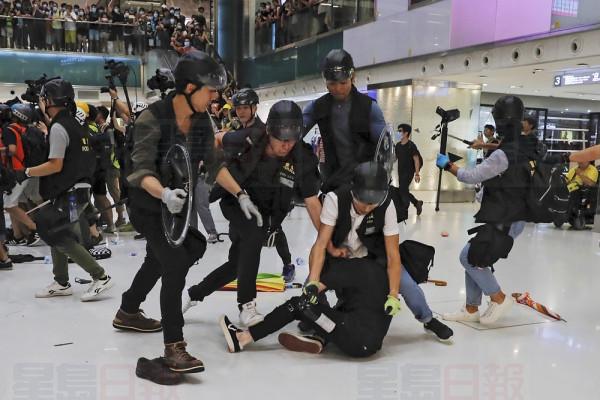 A protester is tackled by policemen after a scuffle inside a shopping mall in Sha Tin District in Hong Kong, Sunday, July 14, 2019. Police in Hong Kong have fought with protesters as they broke up a demonstration by thousands of people demanding the resignation of the Chinese territory's chief executive and an investigation into complains of police violence. (AP Photo/Kin Cheung)