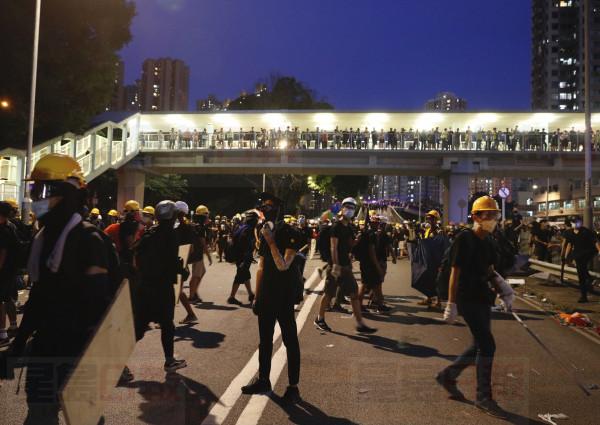 Protesters on a road near the Yuen Long district in Hong Kong on Saturday, July 27, 2019. Hong Kong police on Saturday fired tear gas and swung batons at protesters who defied authorities' warnings not to march in a neighborhood where six days earlier a mob apparently targeting demonstrators brutally attacked people in a train station. (AP Photo/Vincent Yu)