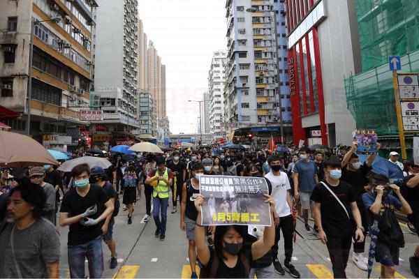 Protesters march through the Mong Kok neighborhood during a demonstration in Hong Kong, Saturday, Aug. 3, 2019. Hong Kong protesters ignored police warnings and streamed past the designated end point for a rally Saturday in the latest of a series of demonstrations targeting the government of the semi-autonomous Chinese territory. (AP Photo/Vincent Thian)