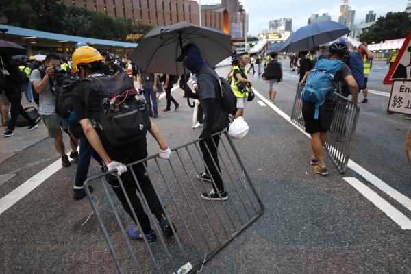 Protesters drag metal barricades onto a highway during a demonstration in Hong Kong, Saturday, Aug. 3, 2019. Hong Kong protesters ignored police warnings and streamed past the designated endpoint for a rally Saturday in the latest of a series of demonstrations targeting the government of the semi-autonomous Chinese territory. (AP Photo/Vincent Thian)