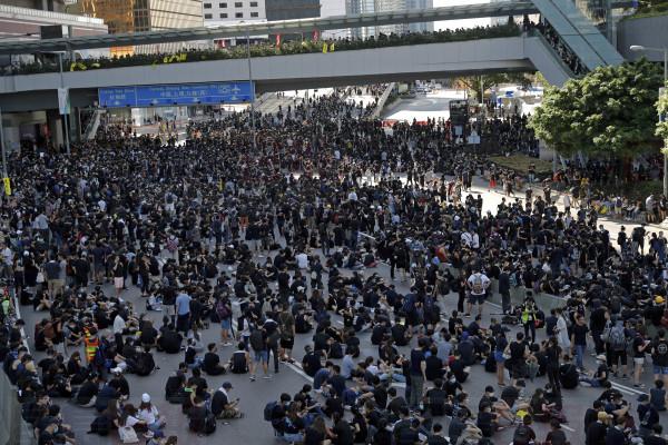 Protesters sit on the roads near the Legislative Council building and the Central Government building during the anti-extradition bill protest in Hong Kong, Monday, Aug. 5, 2019. Droves of protesters filled public parks and squares in several Hong Kong districts on Monday in a general strike staged on a weekday to draw more attention to their demands. (AP Photo/Vincent Thian)