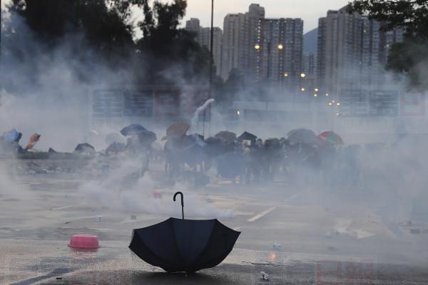 An umbrella is abandoned as protesters pull back from tear gas on Monday, Aug. 5, 2019. Droves of protesters filled public parks and squares in several Hong Kong districts on Monday in a general strike staged on a weekday to draw more attention to their demands that the semi-autonomous Chinese city's leader resign.(AP Photo/Kin Cheung)