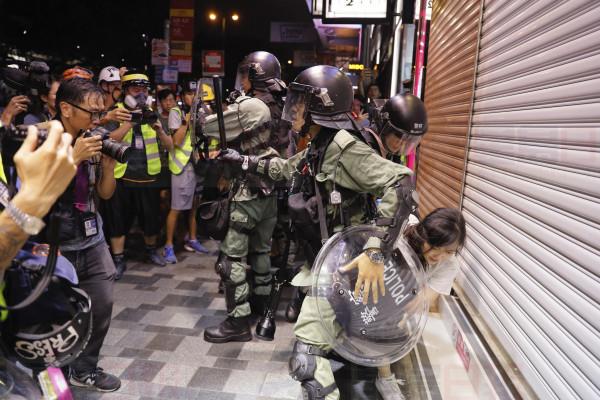 Police detain a girl during a confrontation in Hong Kong on Saturday, Aug. 10, 2019. Hong Kong is in its ninth week of demonstrations that began in response to a proposed extradition law but have expanded to include other grievances and demands for more democratic freedoms.(AP Photo/Kin Cheung)
