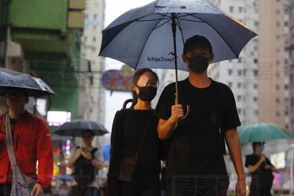 A demonstrator wears an eye patch to show solidarity with a woman injured in her eye by a beanbag during a previous protest as she marches along a street in Hong Kong, Sunday, Aug. 18, 2019. Heavy rain fell on tens of thousands of umbrella-ready protesters Sunday as they started marching from a packed park in central Hong Kong, where mass pro-democracy demonstrations have become a regular weekend activity. (AP Photo/Kin Cheung)