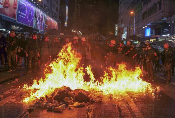 Protesters stand near burning items during a pro-democracy protest in causeway bay, Hong Kong, Saturday, Aug. 31, 2019. Hundreds of people are rallying in an athletic park in central Hong Kong as a 13th-straight weekend of pro-democracy protests gets underway. (AP Photo/Vincent Yu)