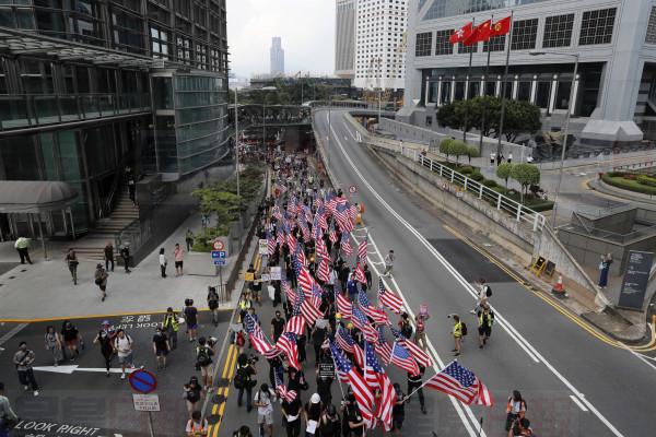Protesters shout slogans and march with United States flags during a protest in Hong Kong, Sunday, Sept. 8, 2019. Demonstrators in Hong Kong plan to march to the U.S. Consulate on Sunday to drum up international support for their protest movement, a day after attempts to disrupt transportation to the airport were thwarted by police. (AP Photo/Kin Cheung)